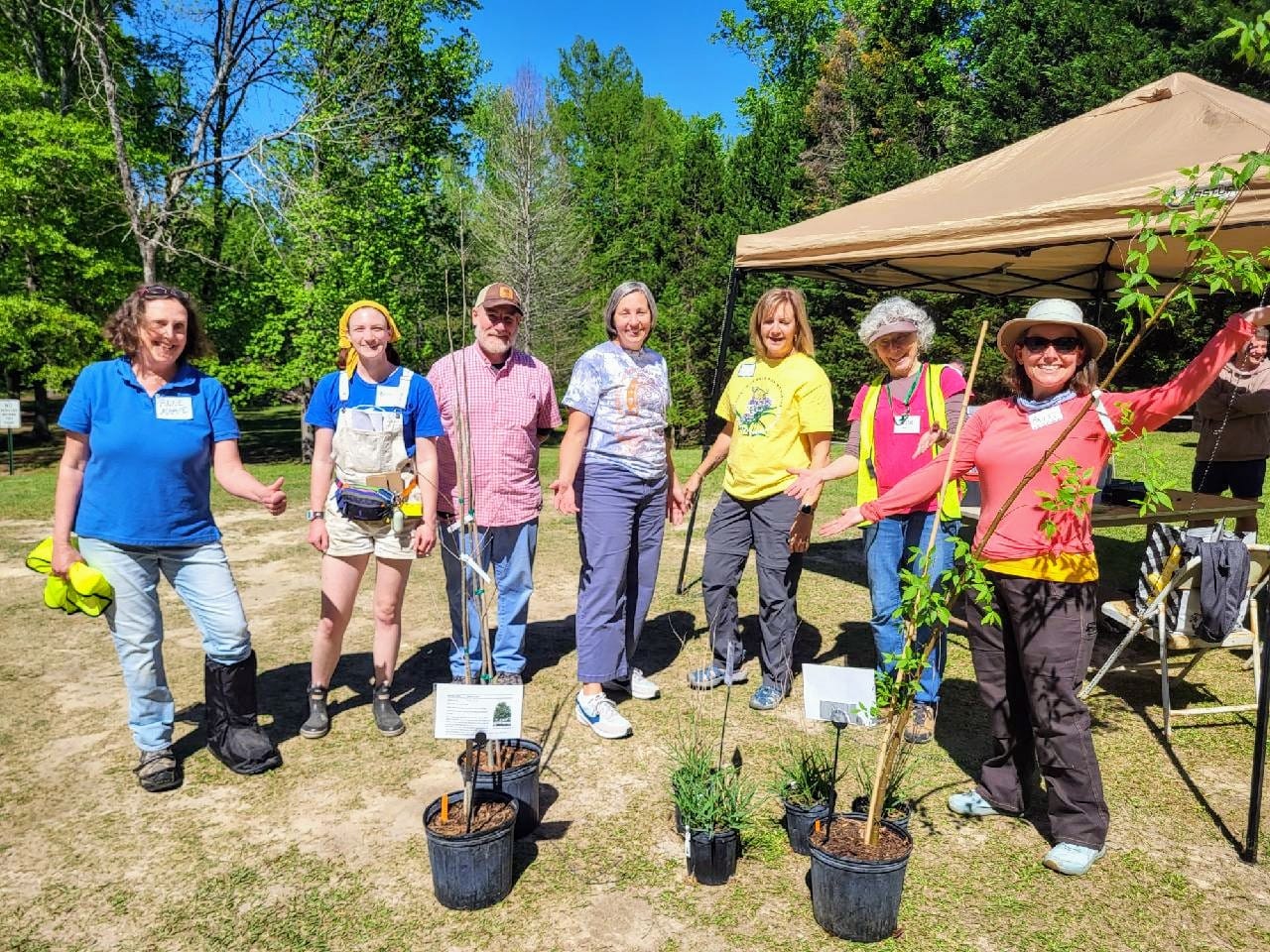 a group of volunteers stand together at a plant sale